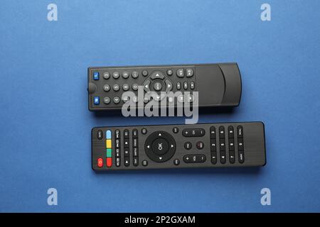 Different remote controls on blue background, flat lay Stock Photo