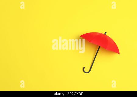 Bright toy umbrella on yellow background, top view. Space for text Stock Photo