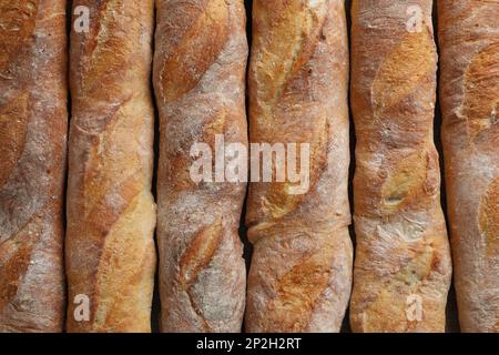 Crispy French baguettes as background, top view. Fresh bread Stock Photo