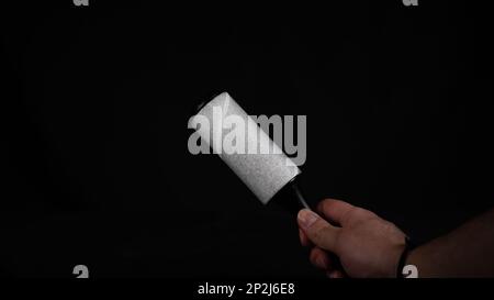 Roller for cleaning clothes from pet hair isolated on black background, close up Stock Photo