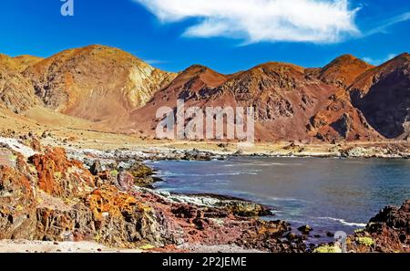 Lonely deserted isolated beautiful bay on the Chilean rocky coast surrounded by colorful rugged mountains on the coastal hiking trail - Pan de Azucar Stock Photo