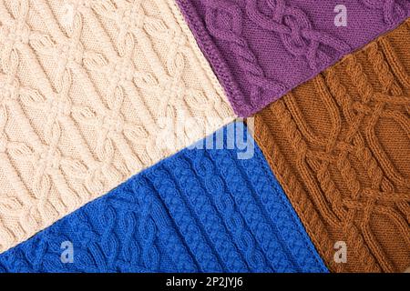 Knitted beige, lilac, brown and blue background. Large knitted fabric with a pattern. Close-up of a knitted blanket. Stock Photo