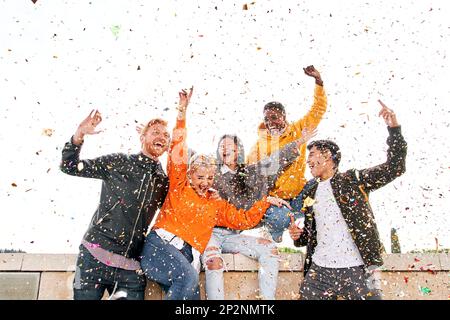 Group of diverse people celebrating outdoors with glitter rain and having fun. Birthday party people Stock Photo