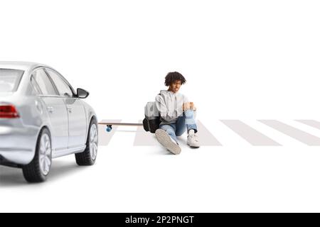 Car at a pedestrian crossing and an african american guy with a skateboard sitting with an injured leg isolated on white background Stock Photo