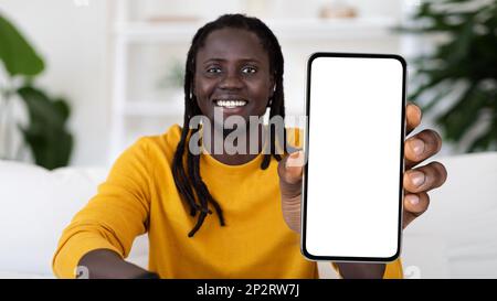 Happy Black Man With Dreadlocks Demonstrating Big Blank Smartphone With White Screen Stock Photo