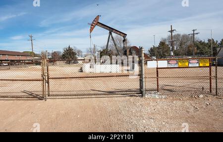 Fenced oil pumpjack in downtown Denver City, Texas, USA Stock Photo