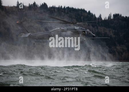 304th Rescue Squadron pararescuemen ascend a rope ladder connected to a 305th RQS HH-60G Pave Hawk helicopter during a combat search and rescue training scenario in the Columbia River Gorge, near Corbett, Oregon, Jan. 12, 2023. The two 943d Rescue Group, Davis-Monthan Air Force Base, Arizona, units carried out various rescue scenarios, ensuring Airmen are able to perform search and rescue operations in a variety of conditions and environments. Stock Photo