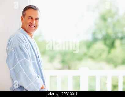Smiling mature man leaning against wall - copyspace. Portrait of a smiling mature man leaning against wall - copyspace. Stock Photo