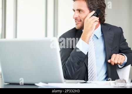 Business man using cell phone and laptop. Smart middle aged business man using cell phone and laptop. Stock Photo