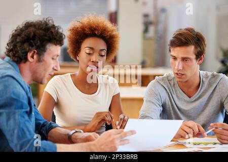 Putting their heads together on the project. a group of colleagues collaborating with each other on a project in an office. Stock Photo