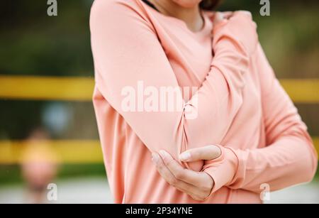 Volleyball, elbow pain and woman holding arm from fitness, exercise and beach workout injury. Sport, outdoor and athlete accident with training, arms Stock Photo