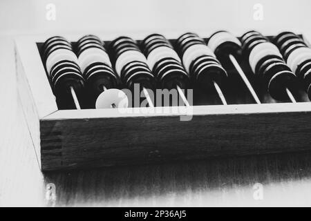 Old wooden abacus for counting money on a wooden table close-up black and white photo Stock Photo