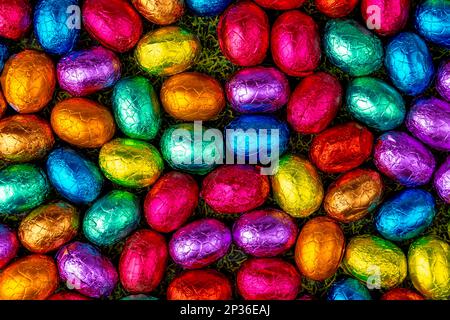 Colourful Easter candy on grass, chocolate eggs, full size Stock Photo