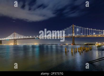 San Francisco Bay Bridge lights at night, reflecting of the water in the Bay, long exposure. Lights turn off on March 5th, 2023 Stock Photo