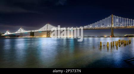 San Francisco Bay Bridge lights at night, reflecting of the water in the Bay, long exposure. Lights turn off on March 5th, 2023 Stock Photo