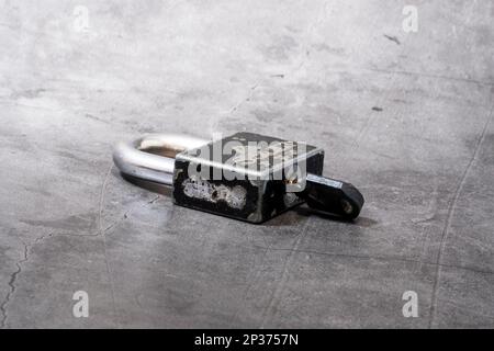 Rusty safety padlock and key old used isolated on dark background Stock Photo