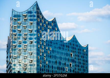 Stunning closeup of the famous glossy glass facade of the iconic Elbphilharmonie concert hall landmark in Hamburg, showcasing its wave-like design. Stock Photo