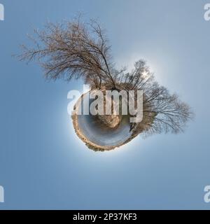 green tiny planet in blue sky with sun and beautiful clouds. Transformation of spherical panorama 360 degrees. Spherical abstract aerial view. Curvatu Stock Photo