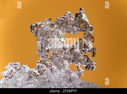 Ephemeral art, ice crystals from frozen snow against a coloured background, Valais, Switzerland Stock Photo