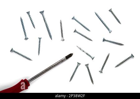 Screwdriver and a group of screws isolated on white background, top view Stock Photo