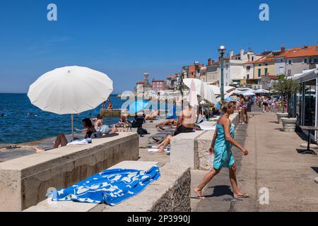 Piran, Slovenia, people relax at seaside waterfront in resort town on the Adriatic Sea Stock Photo