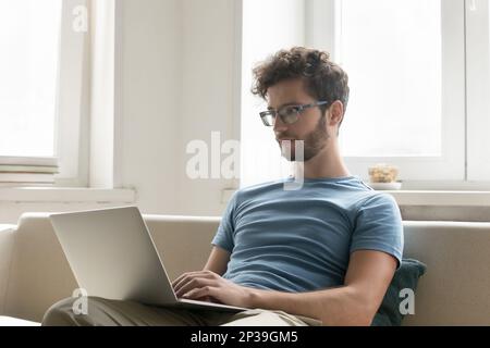Focused freelance employee guy in glasses working at home Stock Photo