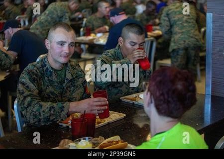 U.S. Marine Corps Pfc. Benjamin Turechek, a Marine with Delta Company 2nd Recruit Training Battalion, talks to Tonya Aron, an educator with 9th Marine Corps District, Western Recruiting Region, during a Warrior’s Breakfast at Marine Corps Base Camp Pendleton, Calif. on Feb. 8, 2023. The Educators Workshop is an opportunity for teachers and those who work with high school students to experience recruit training and learn about the transformation young people make to become Marines. Turechek was recruited out of Recruiting Station Denver, Colo. Stock Photo