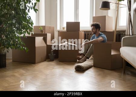 Young property buyer man sitting on parqueted heating floor Stock Photo