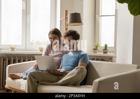 Happy focused young attractive couple speaking on video call Stock Photo