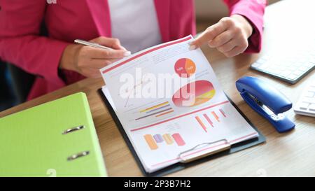 Manager working with financial reports while sitting at table in office. Stock Photo