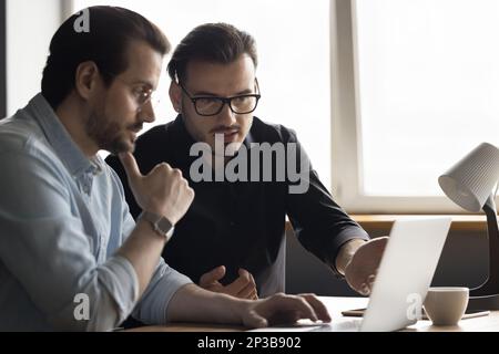 Focused engaged software developers discussing online application Stock Photo