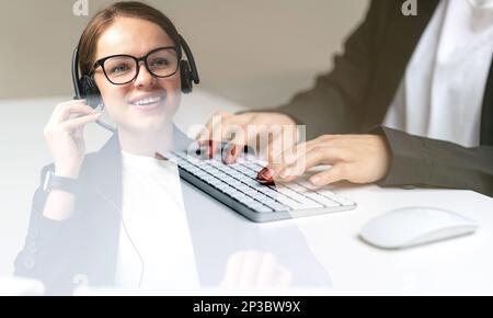 Woman contact center agent talking with customer using headset. Stock Photo