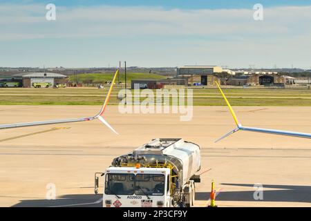 Austin, Texas - February 2023: Delta Aircraft refuelling tanker truck parked between the wing tips of two aircraft at the city's airport Stock Photo