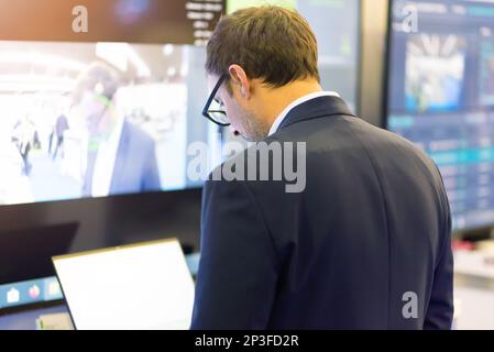IT Software Engineer Working on a Laptop at his Desk. Diverse Workplace with Professionals. Front View Shot Stock Photo