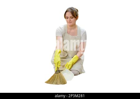 A woman sweeps the floor with a broom when cleaning the home kitchen, isolated on a white background Stock Photo