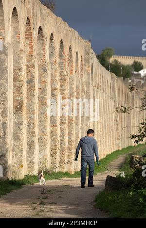 Dog walker below the Usseira Aqueduct built in 1573, Obidos, Central Region, Portugal, Europe Stock Photo