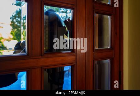 Thief in balaclava peeks through the windows Stock Photo - Alamy