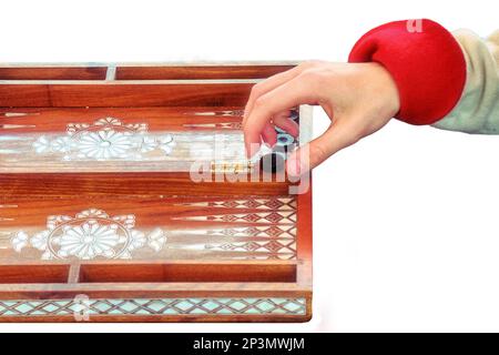 Hands of backgammon players, isolated on a white background. Two people are playing at the retro board, isolated on a white background. Historical rec Stock Photo