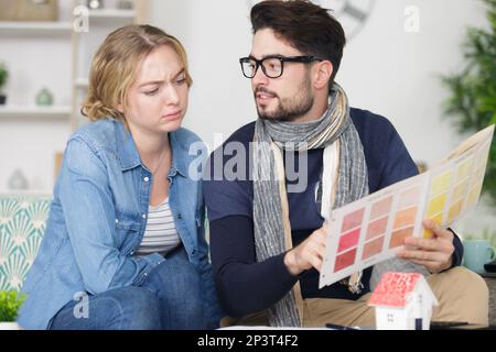 couple choosing paint colour from swatch Stock Photo