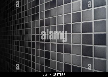 Bathroom wall made of small light gray and dark gray mosaic tiles and silver gray grout Stock Photo