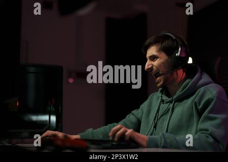 Male cybersport gamer screaming while playing video game Stock Photo