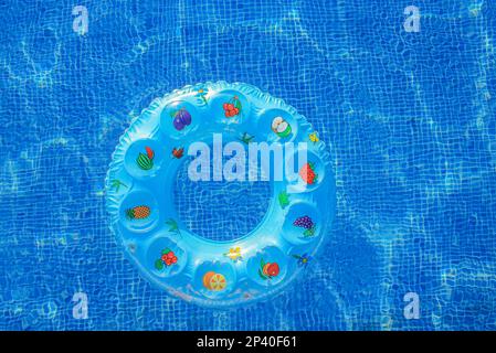 Colorful inflatable ring donut toy in swimming pool water aerial view from above, family vacation holiday resort background Stock Photo