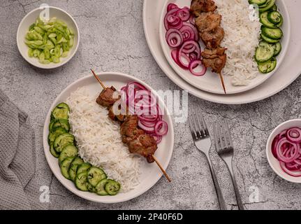 Food photography of grilled meat, kebab, bbq, roasted, pork, lamb, marinade, onion, rice, salad, cucumber Stock Photo