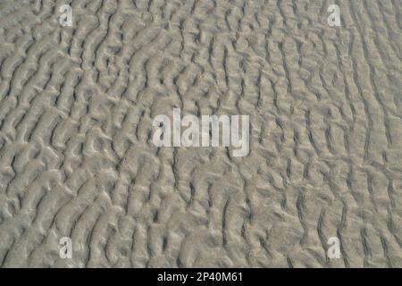 Wet sand texture left by water, abstract natural scene on a sandy beach shore, Spain Stock Photo