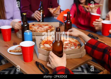 Group of friends with tasty pizza and drinks at home, closeup Stock Photo