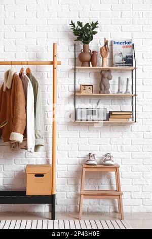 Interior of stylish hall with rack and shelf Stock Photo - Alamy