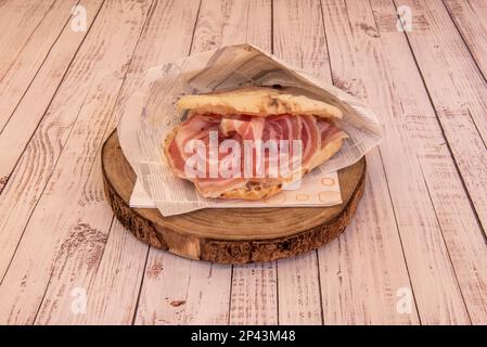 A wonderful Italian sausage sandwich with freshly baked thin bread on a wooden plate Stock Photo