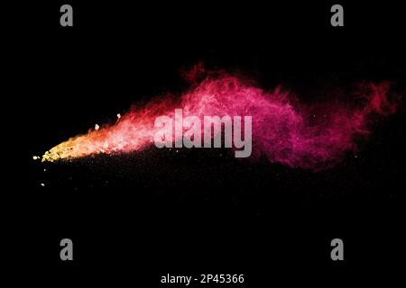 Split debris of stone exploding with red dust against black background. Stock Photo