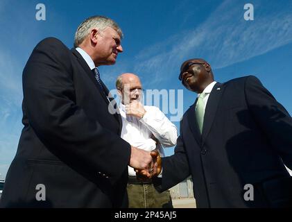 Franklin Graham, left, shakes hands with Liberian Ambassador to the U.S.,  Jeremiah C. Sulunteh Wednesday, Oct. 1, 2014, in Charlotte, N.C. The  Christian relief agency Samaritan's Purse, headed by Graham, is airlifting  tons of protective equipment and ...