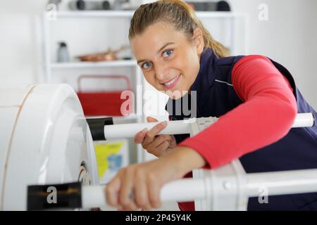 female technician servicing a boiler using tablet computer Stock Photo